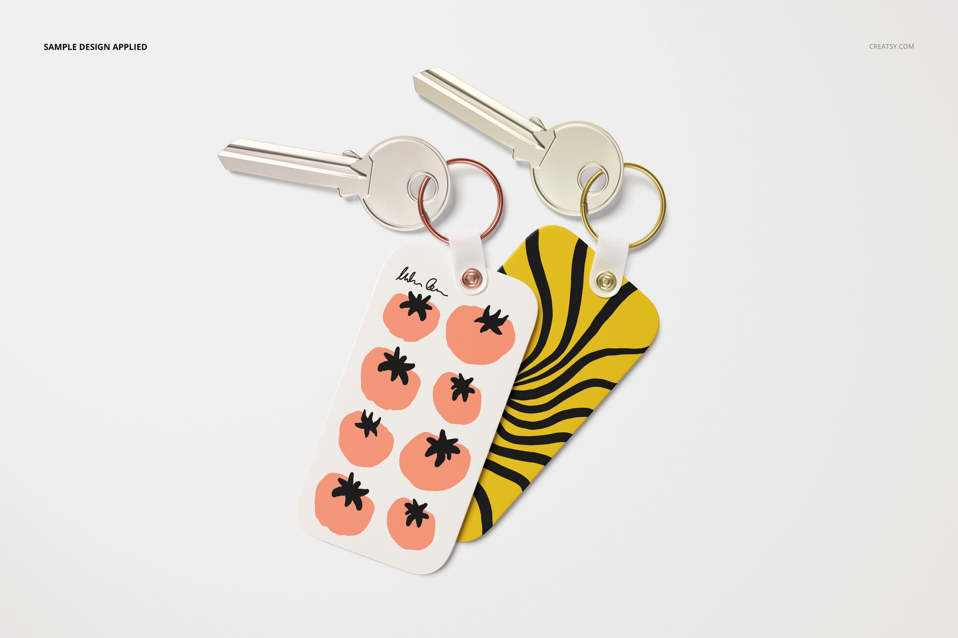 PSD mockup of two key tags with metal rings, displaying playful tomato illustrations and wavy yellow-black patterns.