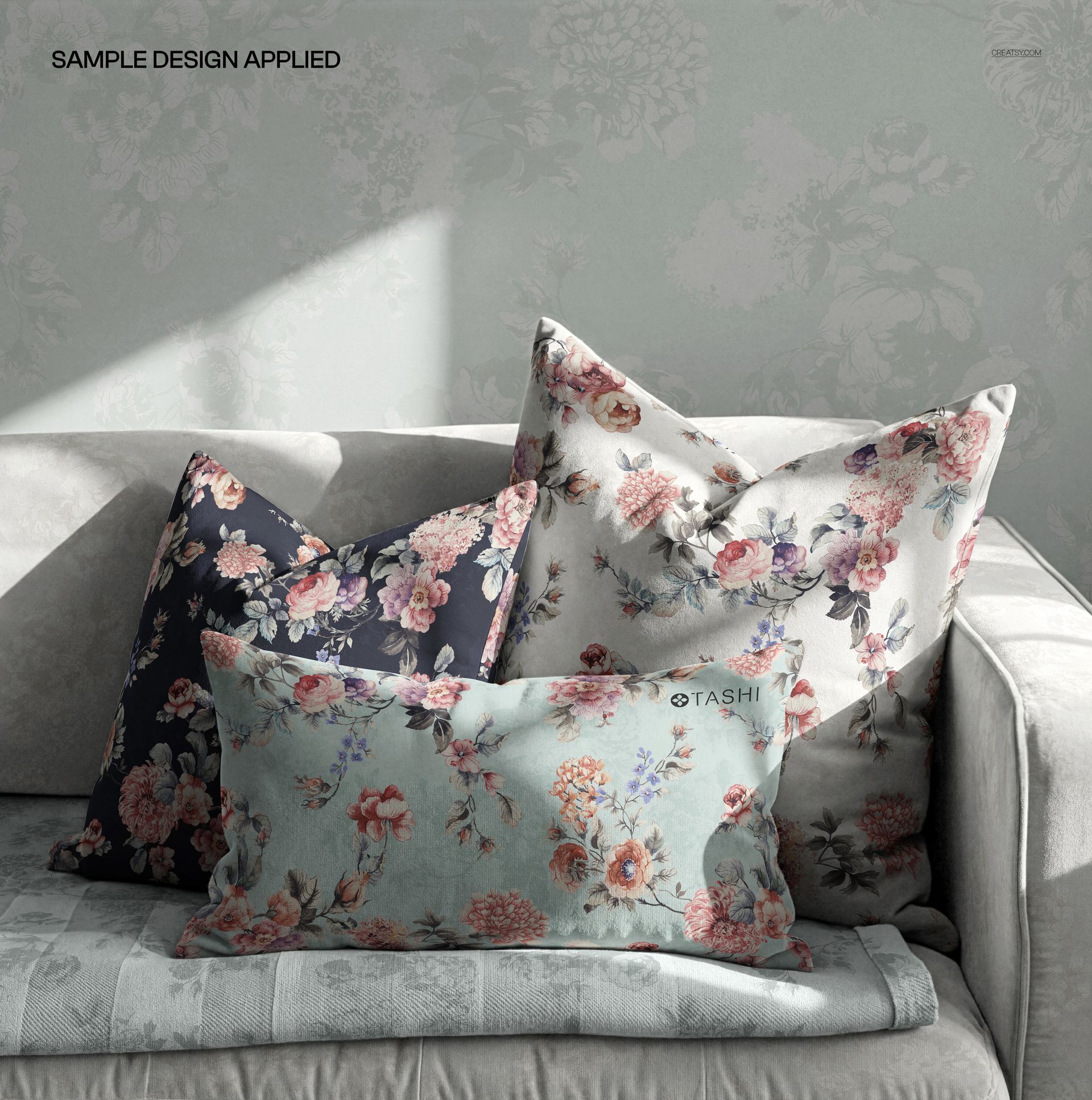 Three decorative pillows featuring floral designs in various colors displayed on a sofa, shown in a PSD mockup scene.