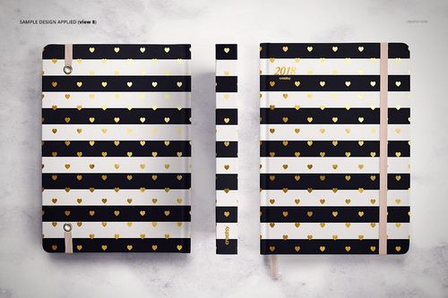 PSD mockup showing a planner with alternating black and white stripes and gold heart accents, displayed flat and upright.
