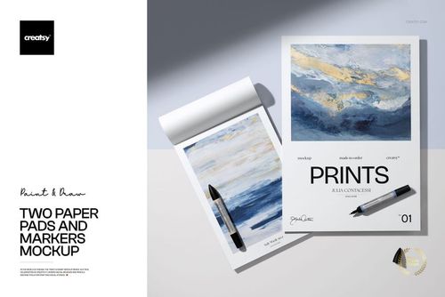 PSD mockup showing two paper pads with realistic shadows, marker props, and artistic prints in a bright studio setting.