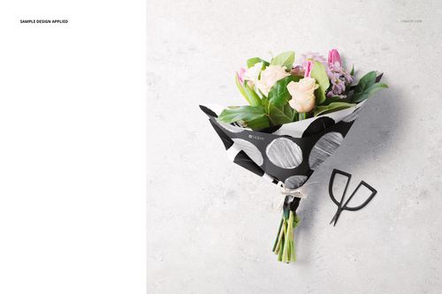 Top view of floral packaging mockup featuring assorted flowers in monochrome wrapping paper with raffia tie.
