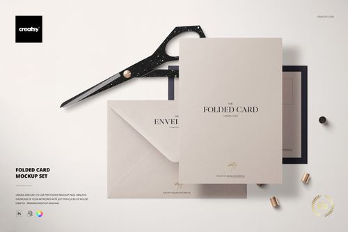 Stationery mockup featuring a folded card, envelope, and accessories arranged on a pale background in a flat lay style.
