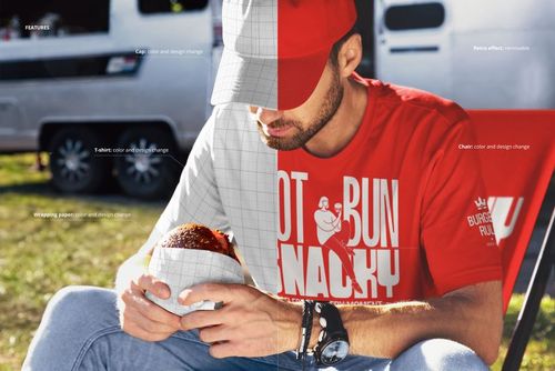 Front view of a person holding a wrapped burger in front of a food truck, with a mockup overlay on the shirt.