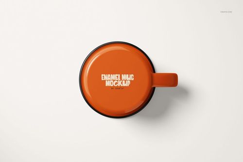 Top view of an orange enamel mug with a black rim and handle, placed on a plain white surface.
