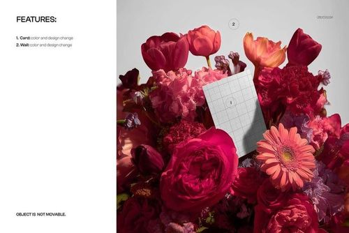 Greeting card mockup placed upright among a vibrant bouquet of red, pink, and orange flowers, viewed from the front.