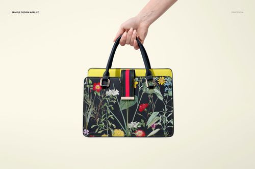 Leather handbag mockup with black handles, vivid flower design on the front, and yellow trim, shown against a light background.
