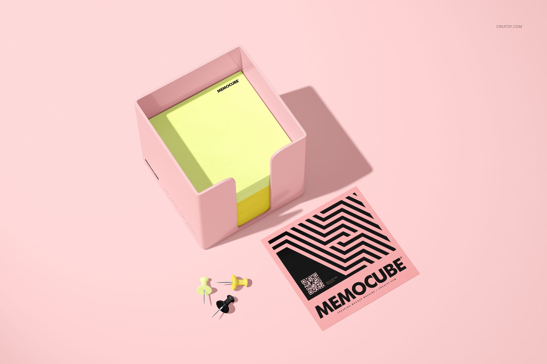 Stationery mockup featuring a memo block cube in a pink acrylic holder, with assorted push pins and a patterned flyer.