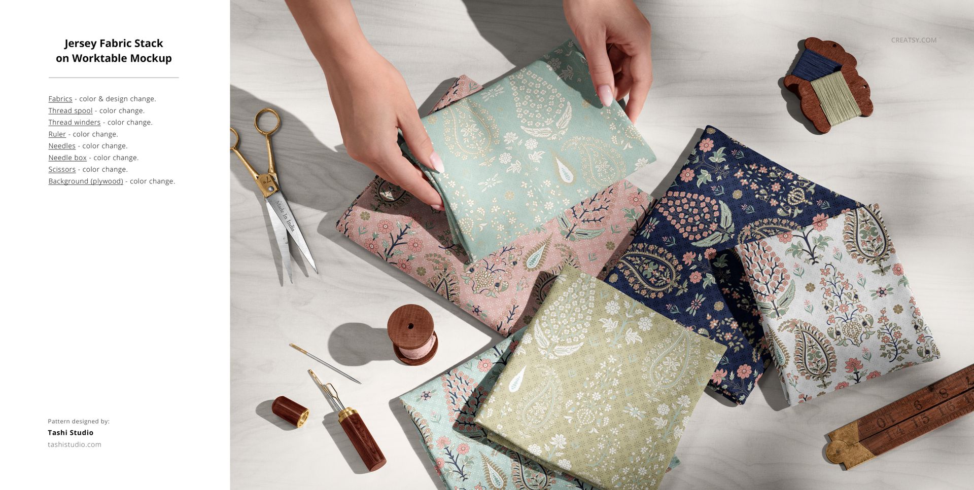 PSD mockup featuring folded jersey fabrics in various botanical prints, accompanied by scissors, thread, and pins in a creative workspace.