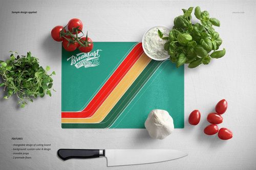 Rectangular glass cutting board mockup on a white surface, featuring a retro stripe design and kitchen props like basil and tzatziki.