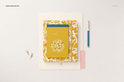Top view of a stationery mockup featuring a floral folder, yellow notebook, blue notepad, gold pen, and small paper clips.