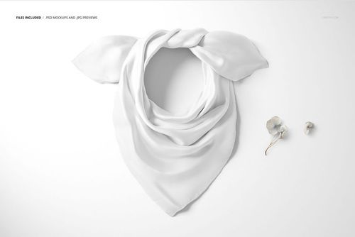 Fashion accessories PSD mockup showing a neatly wrapped white silk scarf and two dried flowers on a clean surface.