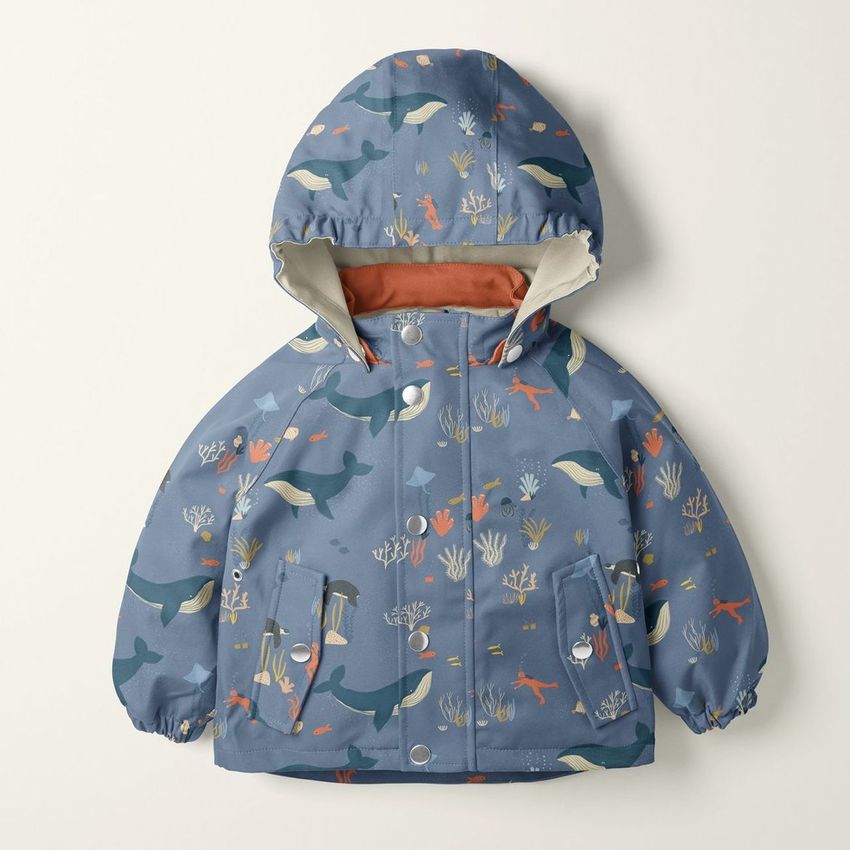 Kids rainwear mockup featuring a blue hooded jacket with ocean-themed illustrations, photographed on a light background.