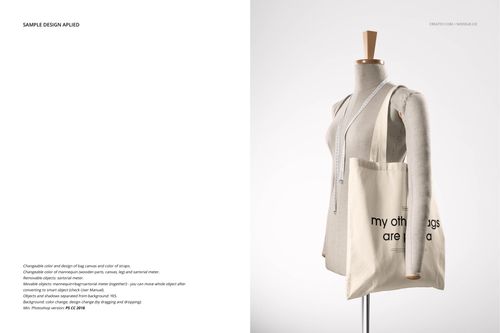 Front view of a beige tote bag mockup hanging on a dress form, featuring black text and a measuring tape draped over the shoulder.