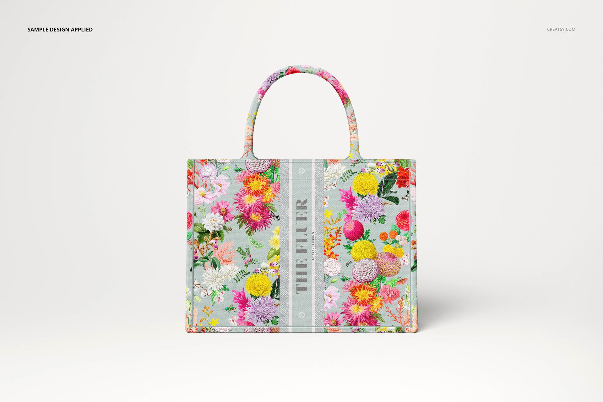 Canvas tote bag mockup featuring a rectangular shape, floral design, and rounded handles, displayed on a plain surface.