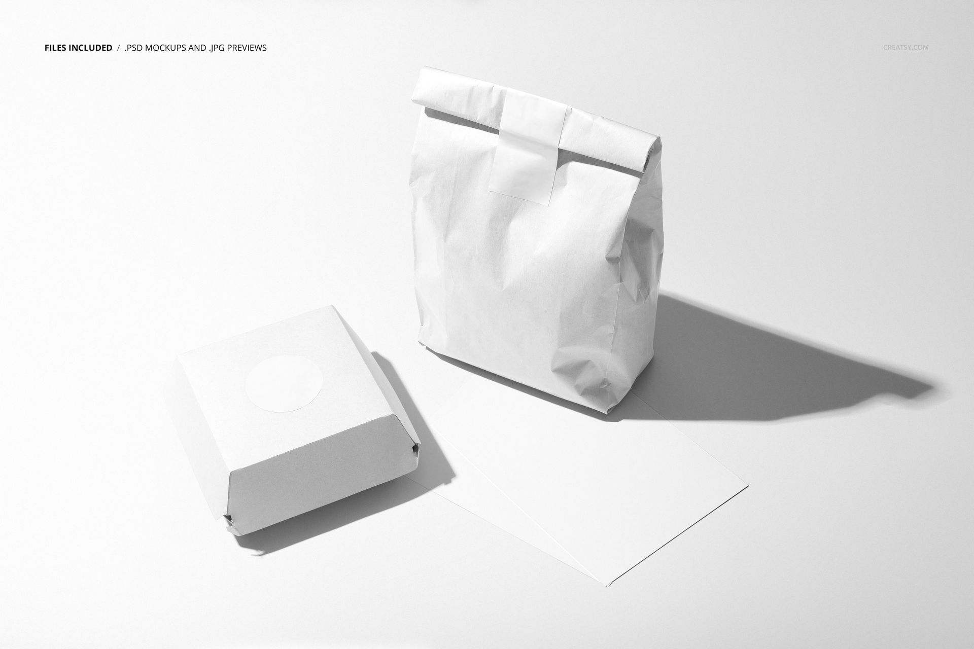 Front view of fast food packaging mockup with a white burger box, paper bag, and blank menu card on a light surface.