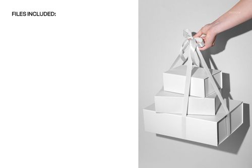PSD mockup featuring a hand holding layered white gift boxes with ribbon, displayed in a minimalist setting.