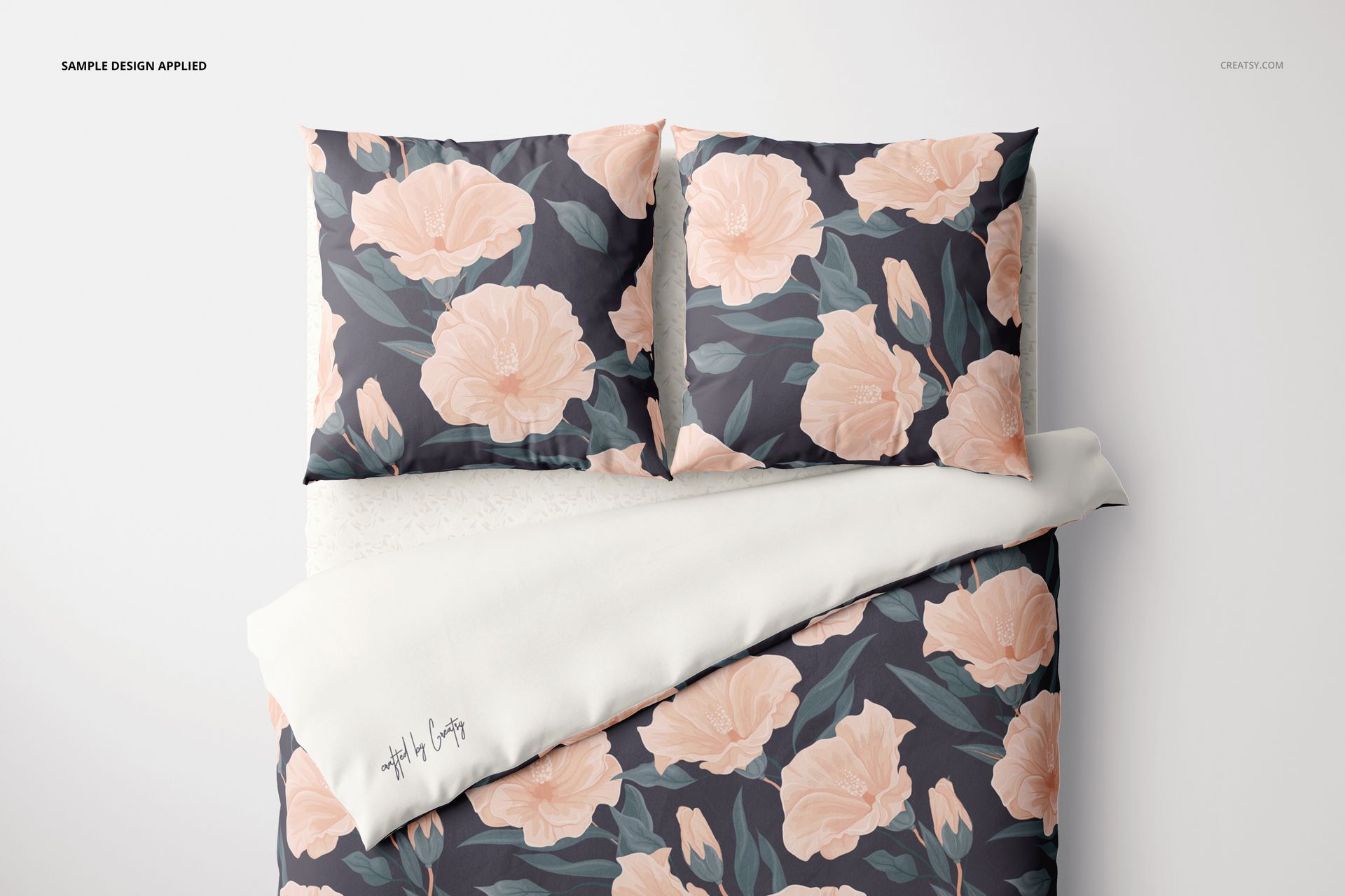 Top-down perspective of bedding mockup with euro pillows, decorated with large peach flowers and leafy accents.