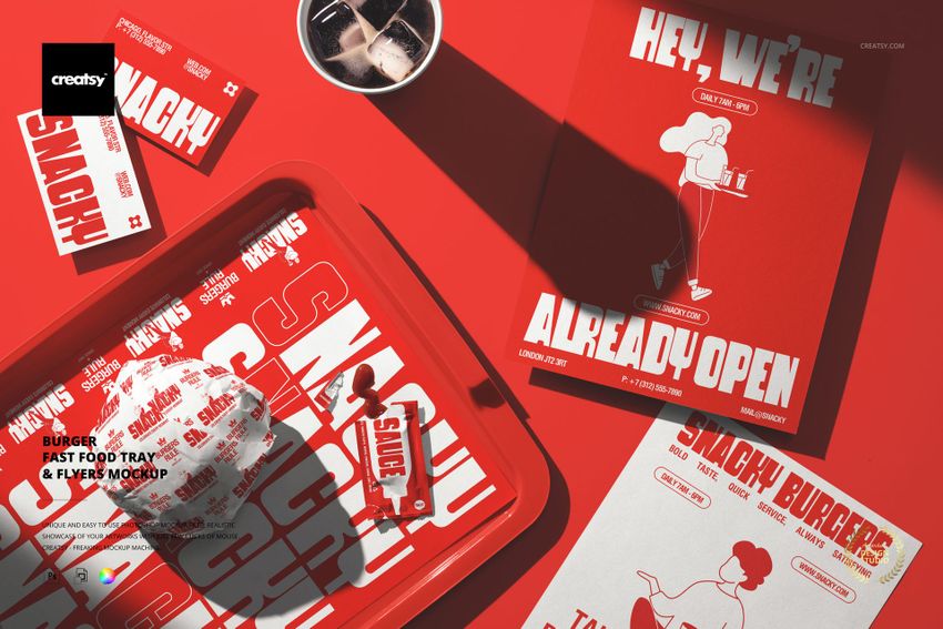 Top view of a fast food tray with burger packaging, red flyers, and utensils on a red surface in a mockup scene.