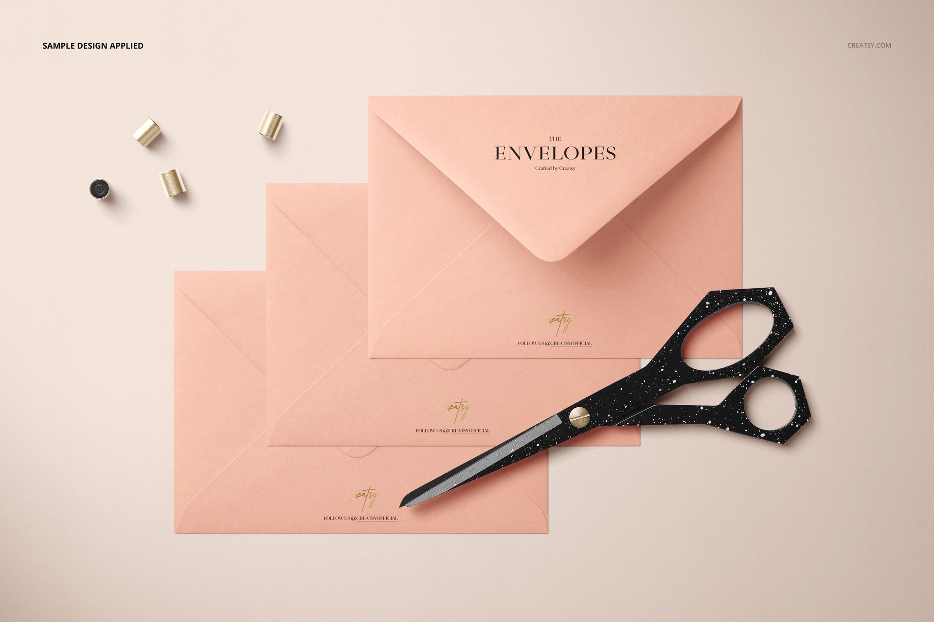 C6 envelope PSD mockup set featuring three pink envelopes, black speckled scissors, and gold stationery pieces.