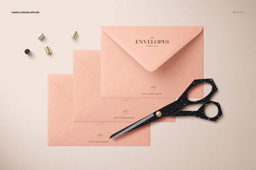 C6 envelope PSD mockup set featuring three pink envelopes, black speckled scissors, and gold stationery pieces.