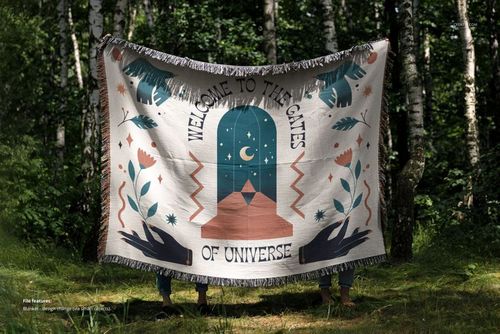 Front view of a jacquard fringed throw blanket mockup featuring a bold graphic pattern, held outdoors among trees.