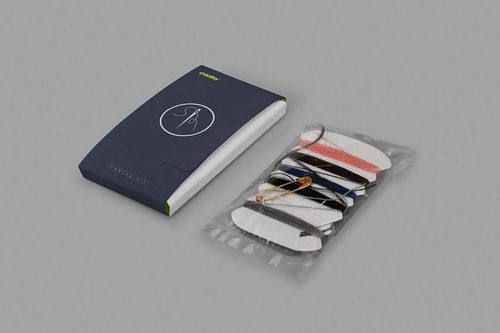 Sewing kit mockup set featuring a navy blue rectangular case with a white edge and a plastic pouch holding threads and a needle on a neutral gray background.