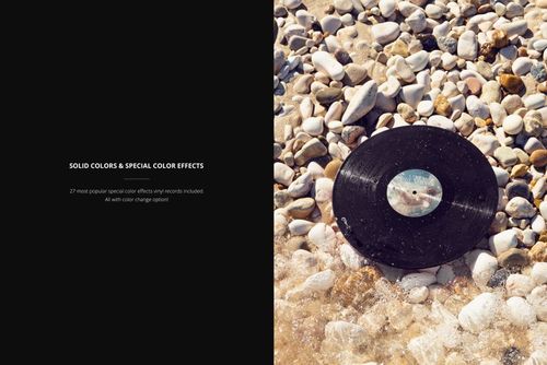 Top view of a black vinyl record on rocky shoreline, surrounded by water and smooth stones, PSD mockup scene.
