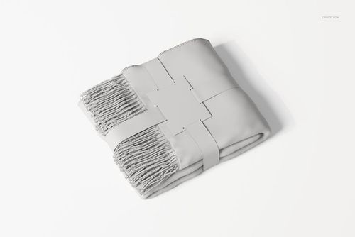 Folded fringe blanket with a visible label, shown from a top view on a white background, featuring textured edges.