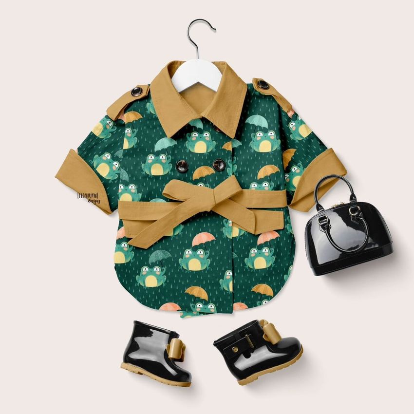 Baby coat mockup featuring a green jacket with a playful frog pattern, displayed with black boots and a small handbag on a light background.