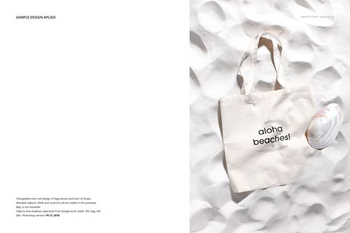 Top view of a beige tote bag mockup on textured white sand, with a shell as a prop and black printed text.