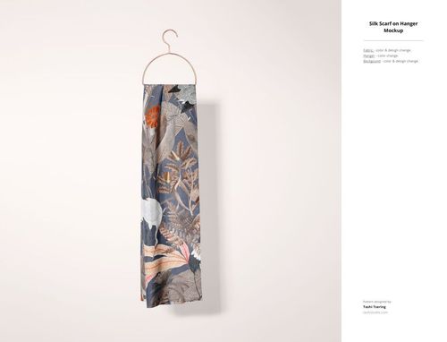 Fabric mockup showing a rectangular scarf with a botanical and abstract pattern hanging on a metal hanger against a light wall.