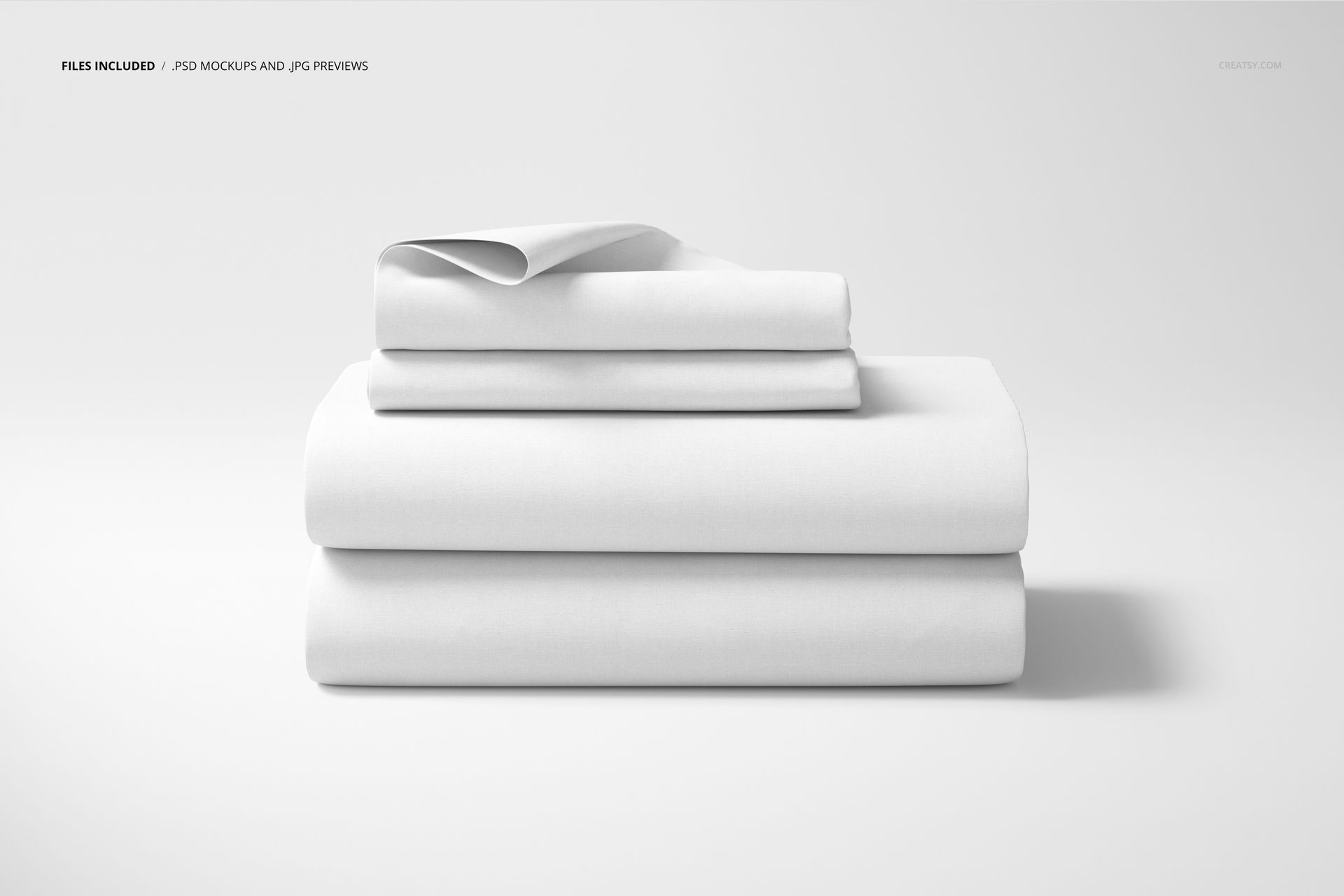 White bedding set mockup showing neatly folded sheets and pillowcases arranged in layers, minimal background.