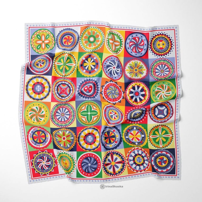 Twill silk scarf mockup featuring a colorful folk art-inspired pattern with geometric and floral motifs on a white background.