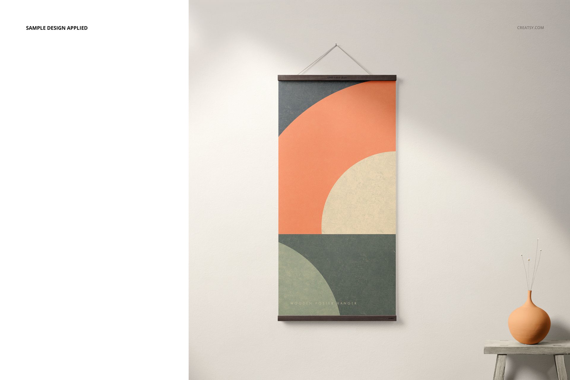 Mockup of a wooden poster hanger with a geometric print in orange, beige, and green, shown above a table with a vase.