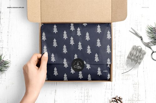 Mailer box mockup with patterned tissue paper inside, pine tree design, displayed on rustic white wood background with props.