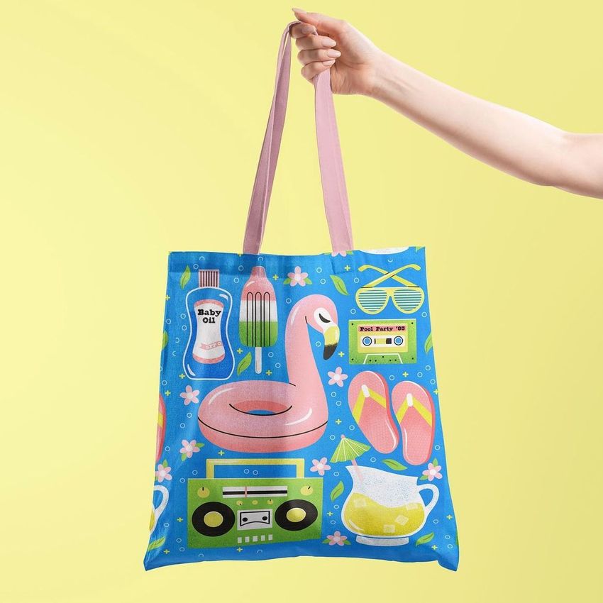 Tote bag mockup featuring a hand holding a blue bag with colorful 80s-inspired pool party illustrations on a yellow background.