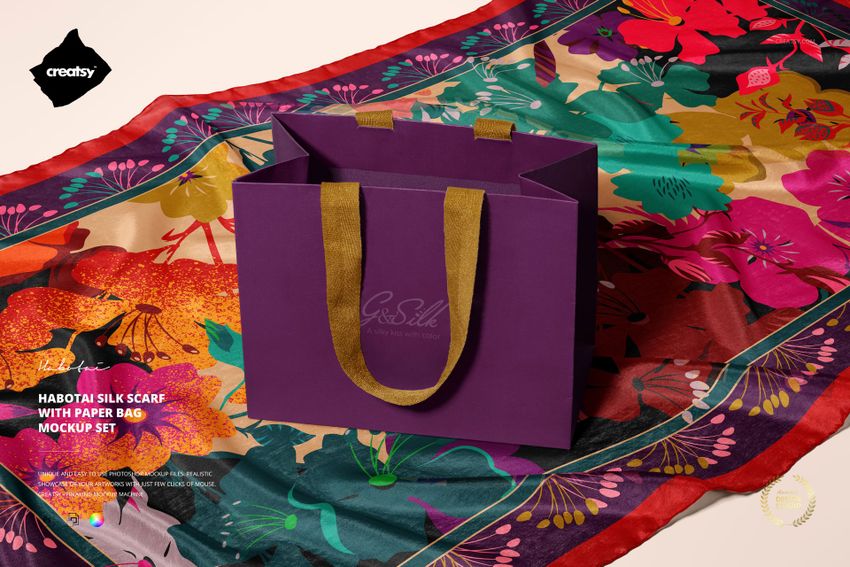 PSD mockup of a fashion accessory scene with a multicolored floral silk scarf and a purple gift bag on top.