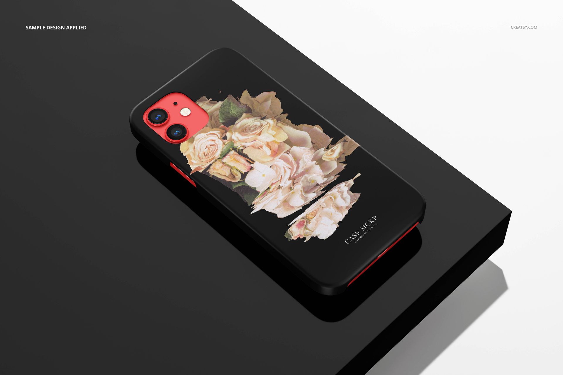 iPhone 12 matte snap case mockup featuring a bouquet of pale flowers, displayed on a reflective black platform.
