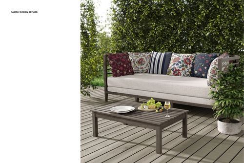 PSD mockup of a patio sofa with multiple colorful pillows, placed on a deck with greenery in the background.