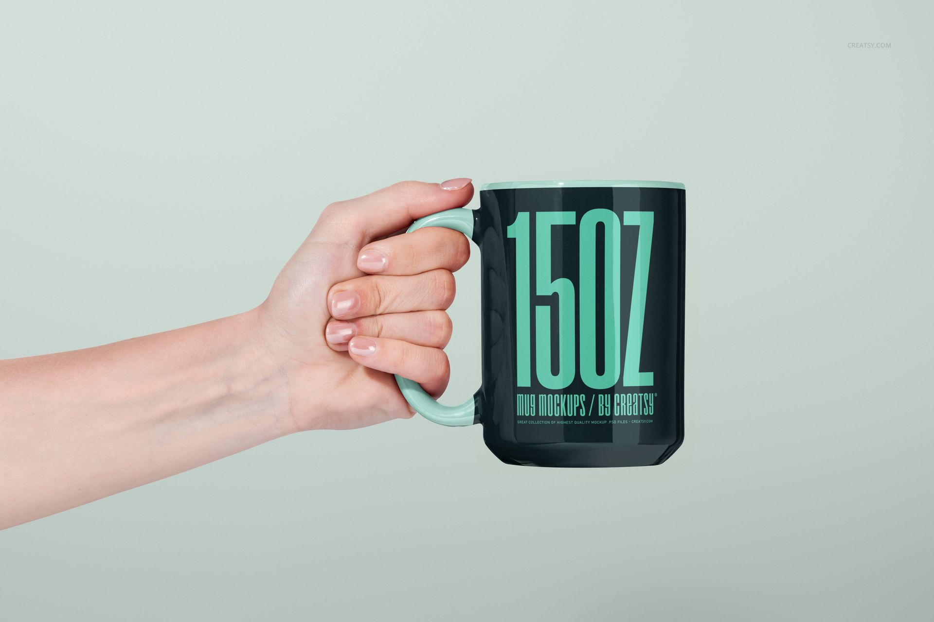 Front view of a 15oz mug mockup, black with mint green handle and large mint green lettering, held by a hand.