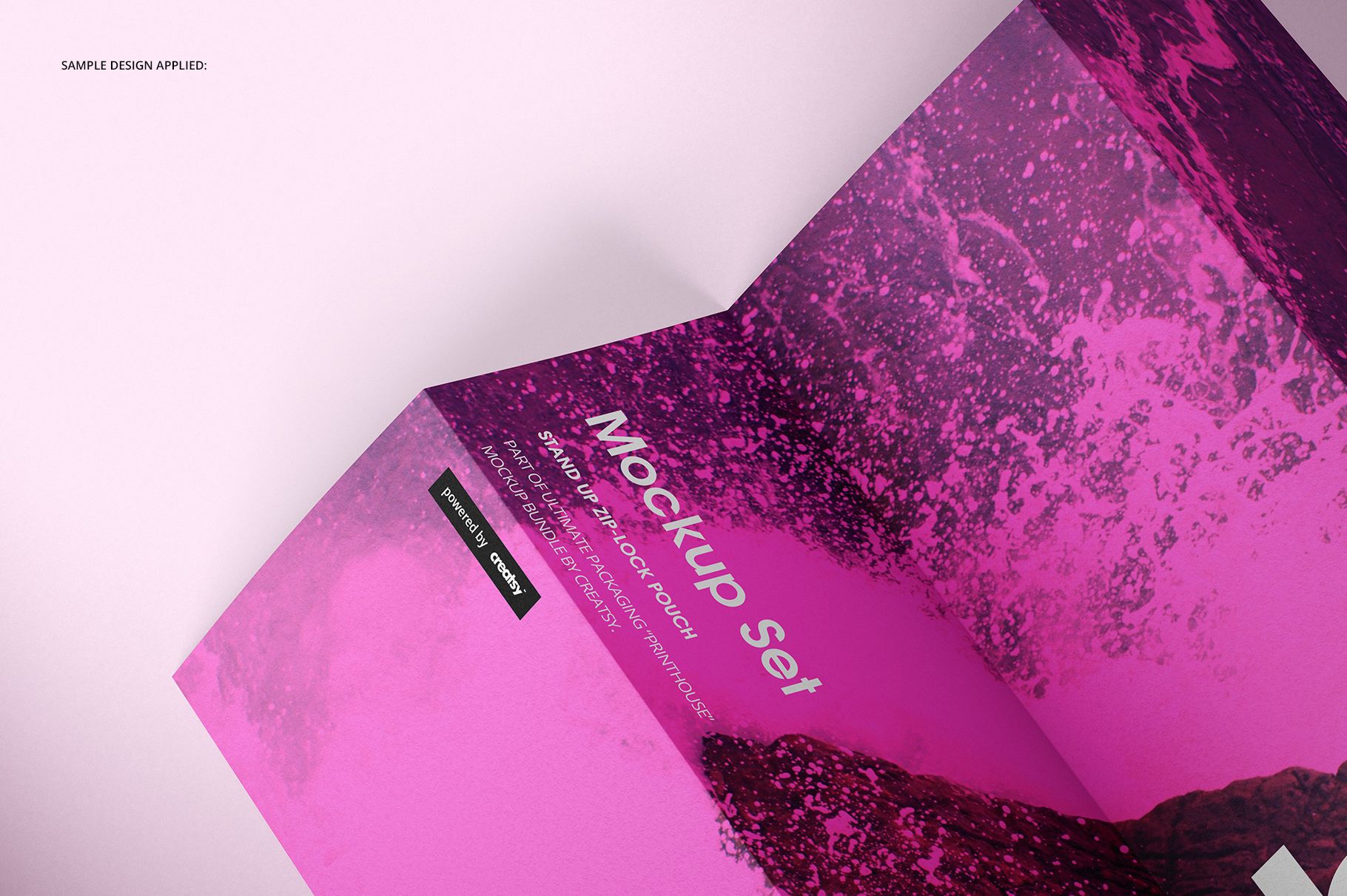 A4 pamphlet mockup with a bold pink and dark abstract design, shown in an angled top view on a light surface.