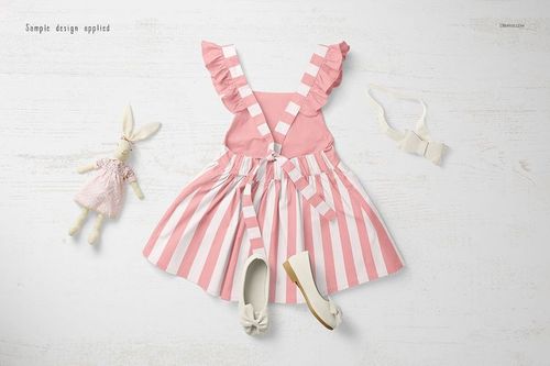 Front view of a pink and white striped baby dress mockup with ruffled straps, displayed on a light wooden surface.