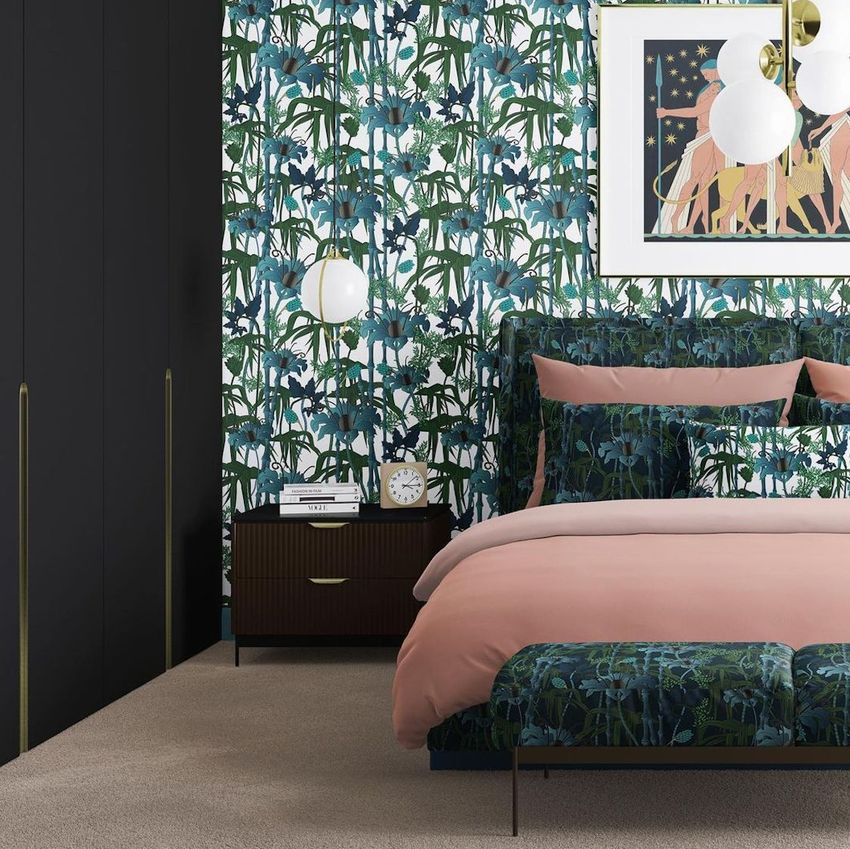 Bedroom scene bedding mockup featuring a bed with botanical patterned duvet and pillows, pink blanket, and dark wood nightstand.