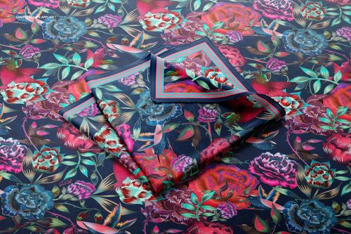 Square silk scarf mockup featuring a folded scarf with vibrant floral patterns on a dark background, top view.