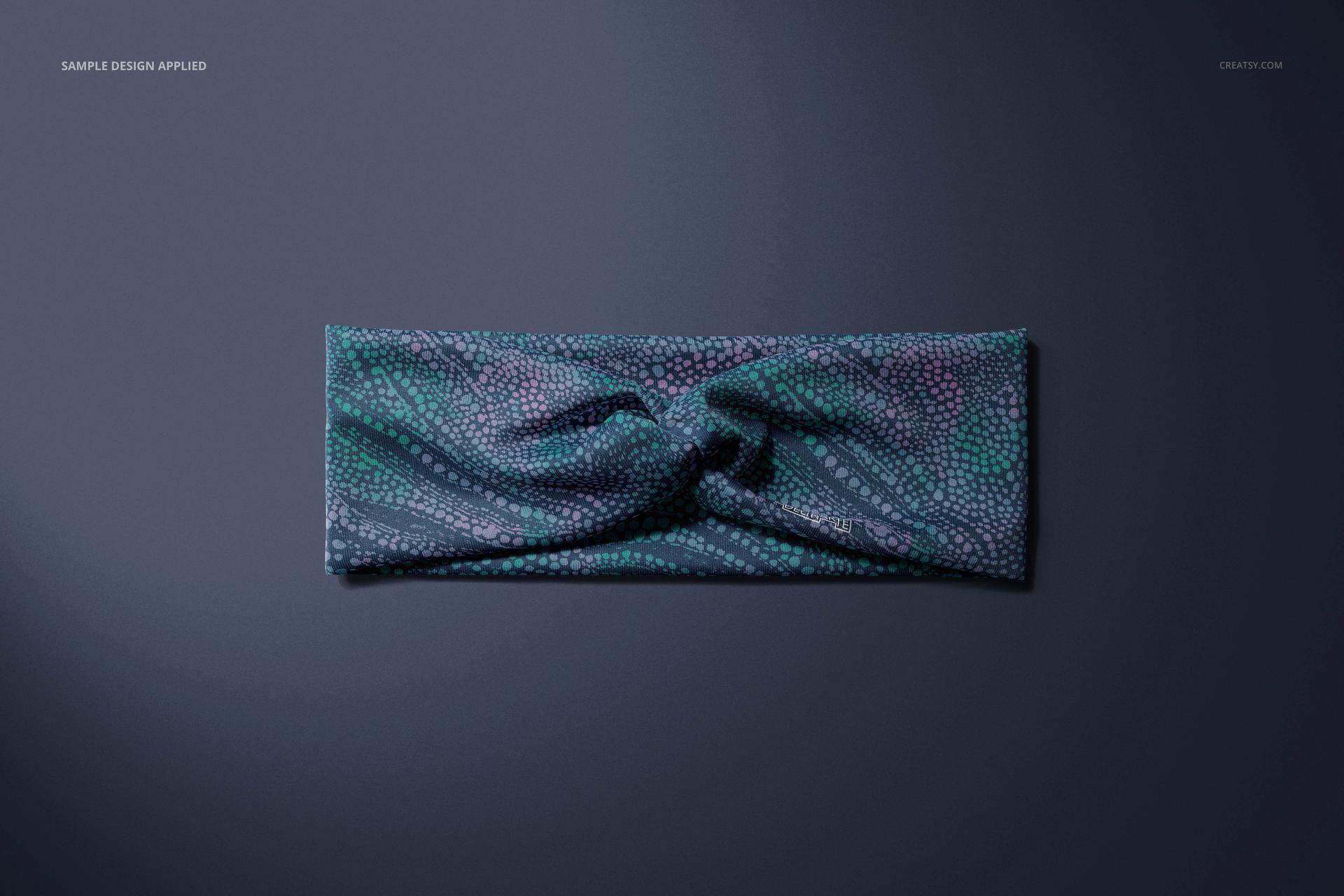 Top view of a faux knot headband mockup featuring a textured blue and teal design on a smooth background.