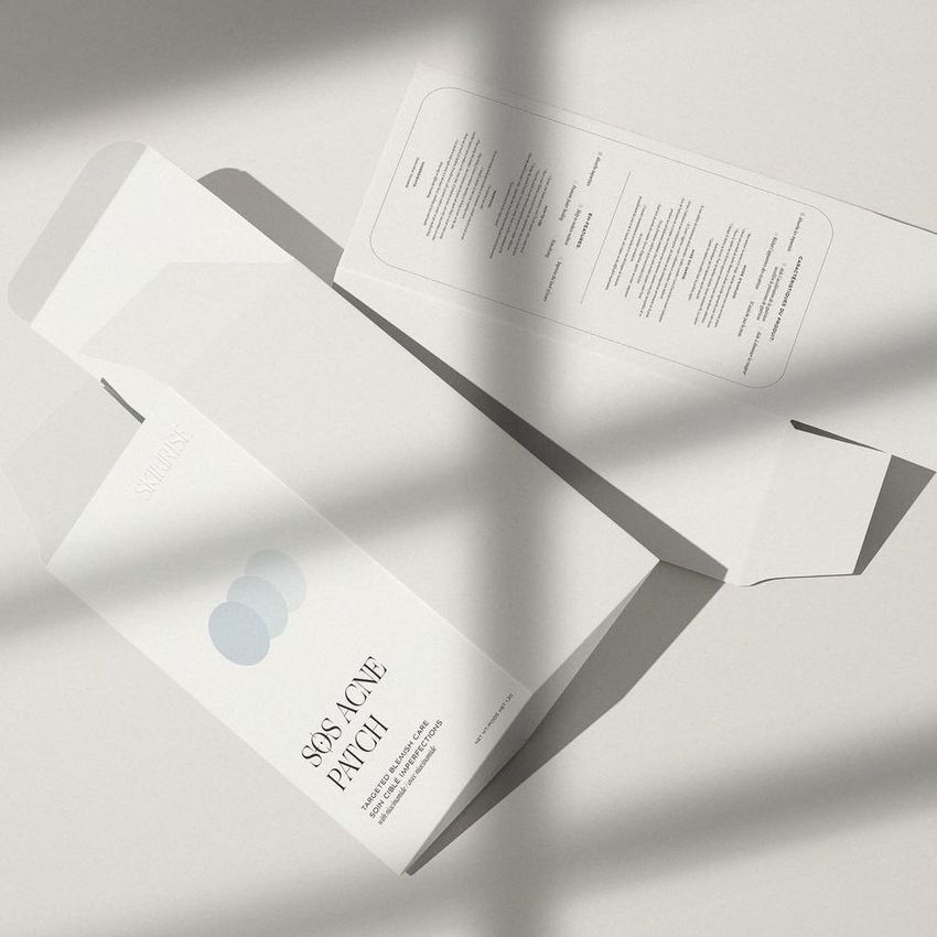 Tuck top crash lock box mockup featuring two unfolded packaging boxes on a light surface with soft shadow patterns.