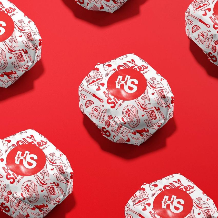 Burger mockup featuring several wrapped burgers on a vibrant red background, with white paper printed in red graphics and text.