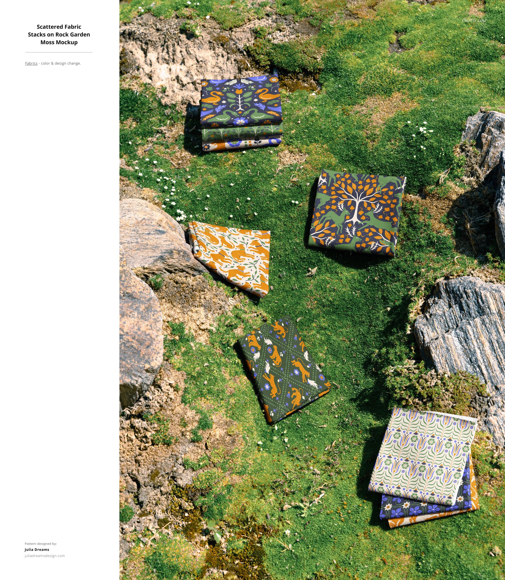Fabric mockup showing several folded textiles with various designs placed on natural moss and stone outdoors.