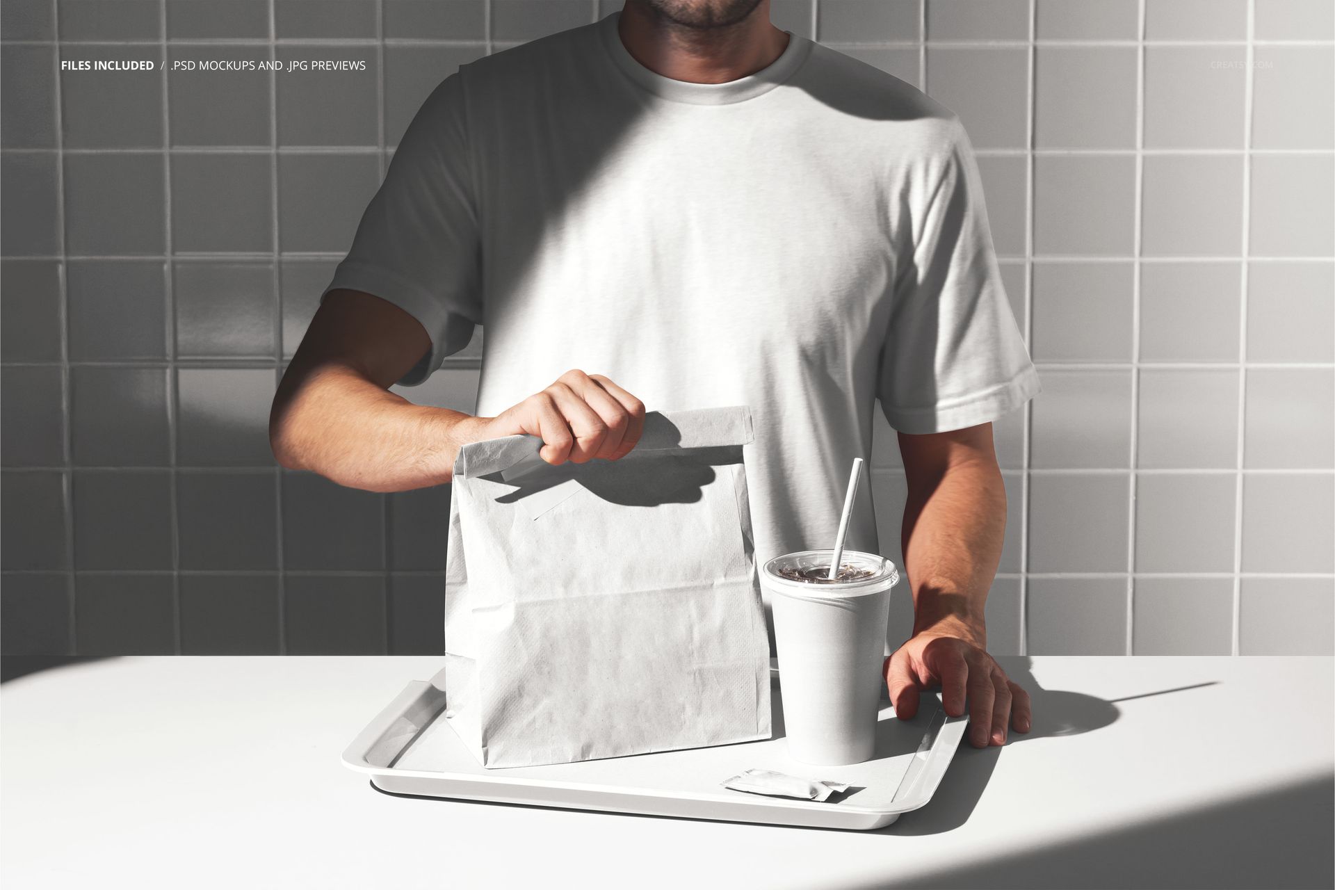 PSD mockup showing a man with a white takeout bag and drink cup on a tray, set in a minimalist tiled interior.