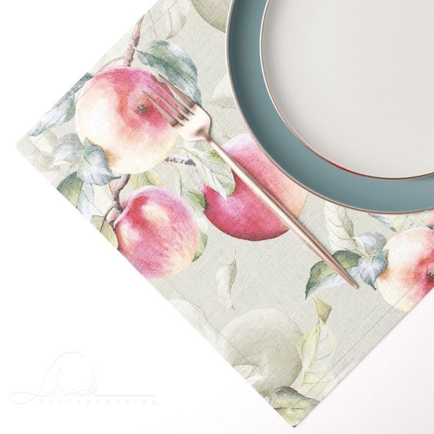 Placemat mockup featuring a watercolor apple pattern, with a blue-rimmed plate and silver fork arranged on top.